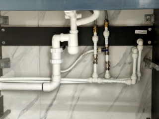 plumbing under a vanity unit with basin